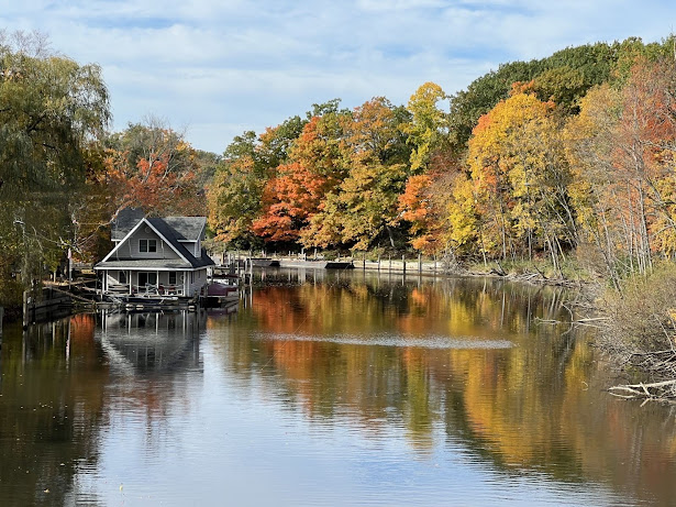 Beautiful fall leaves with a boat house and water